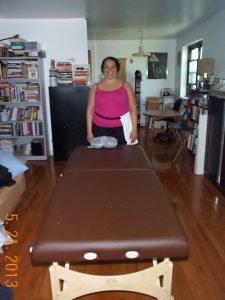 LIcensed Massage Therapist, Kathy Branch, with her massage table